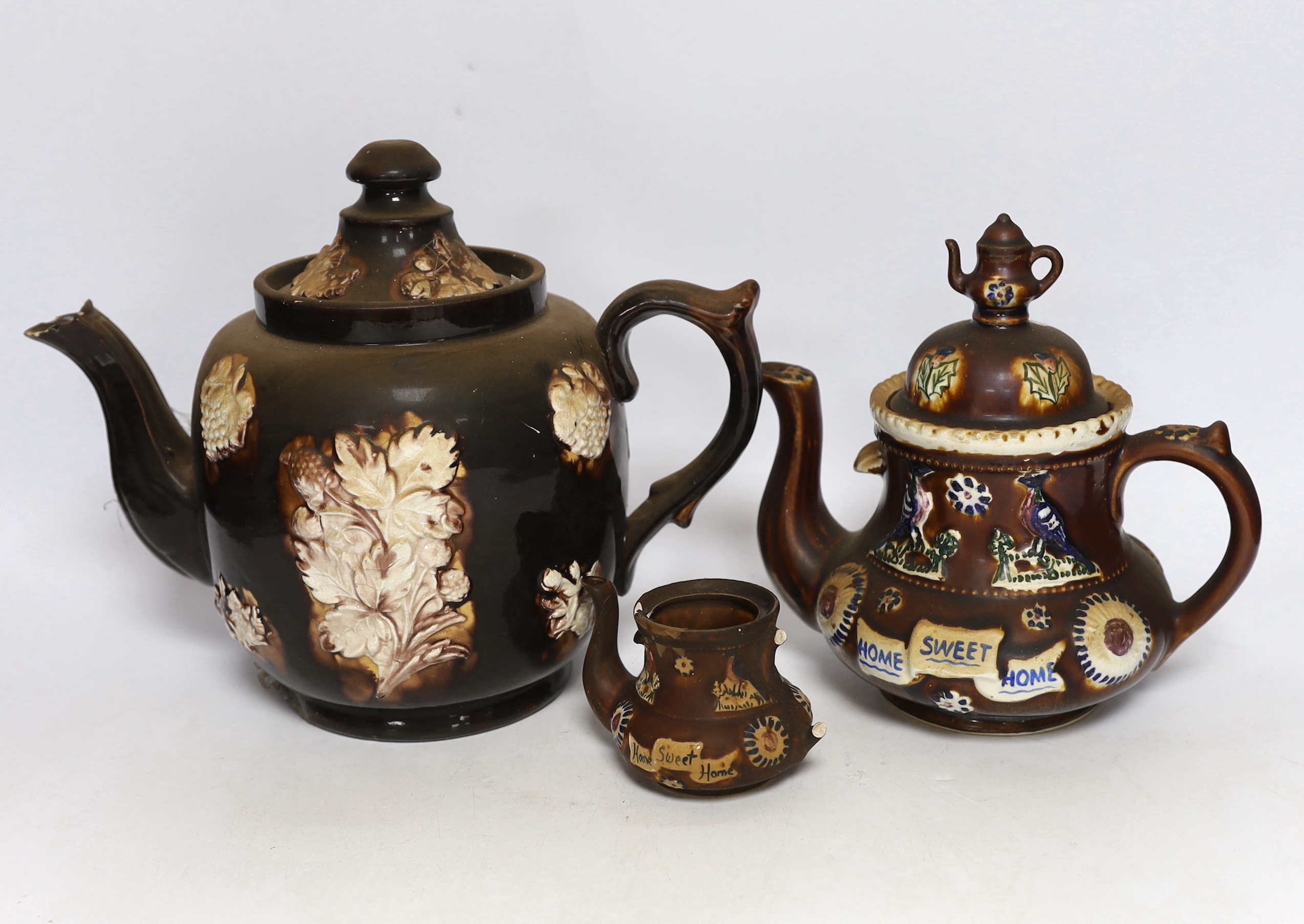 Three 19th century various sized Measham Barge ware teapots, largest 22cm high